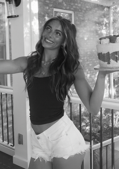 A black and white photo of a woman sitting on a couch.